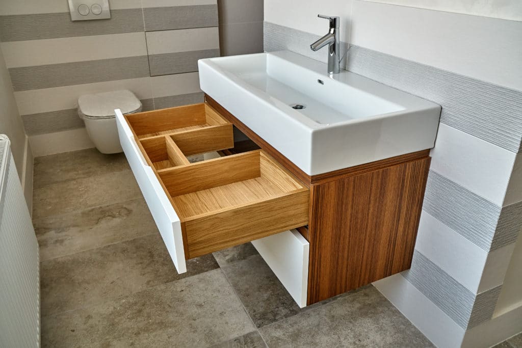 Bathroom console sink vanity in luxury bathroom with teak floor. Stylish interior of modern bathroom. Details furniture